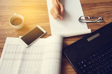 Dizüstü akıllı telefon kahve kalem tutan eller masanın üstüne Kupası