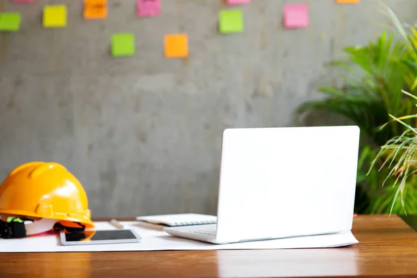 Ingenieur helm op tafel met pc en kleurrijke plaknotities op wa — Stockfoto
