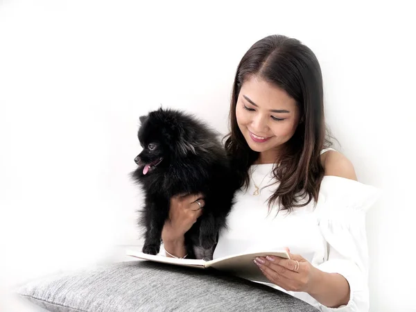 Feliz mujer asiática leyendo un libro y sentada en el suelo con su b — Foto de Stock