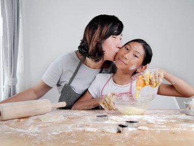 Asya anne evde, hamuru li yaparken kızı öpüşme