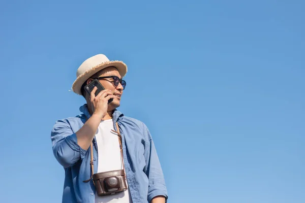Turistické Asiat mluvící mobilní telefon s modrou oblohou v létě. — Stock fotografie