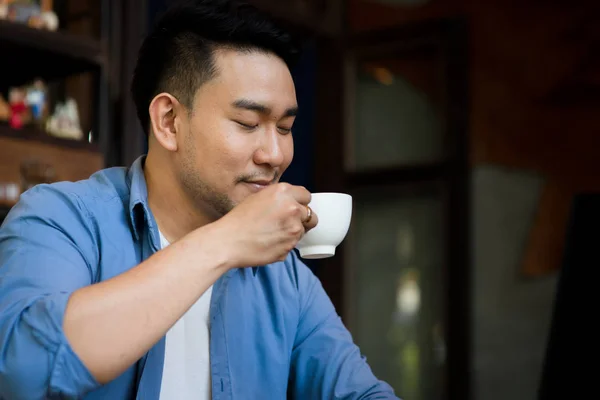 Šťastlivec asijské pít horkou kávu v kavárně, stylu života. — Stock fotografie