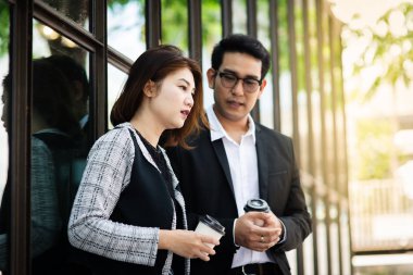 Kahve fincanı tutarak ve onun takım outd ile konuşurken iş kadını