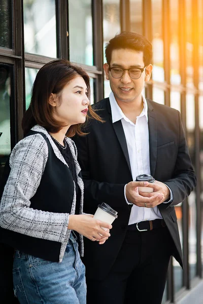 Geschäftsfrau hält Kaffeetasse in der Hand und spricht mit ihrem Team — Stockfoto