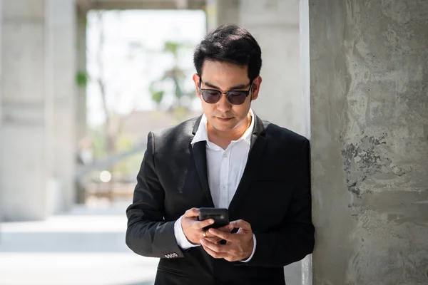 Krásný asijský podnikatel pomocí chytrého telefonu venkovní. — Stock fotografie