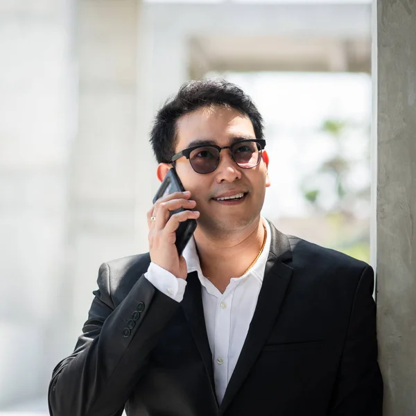 Krásný asijský podnikatel pomocí chytrého telefonu venkovní. — Stock fotografie