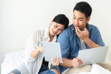 Evde, dizüstü bilgisayar kullanarak mutlu Asya Çift yaşam tarzı kavramı.