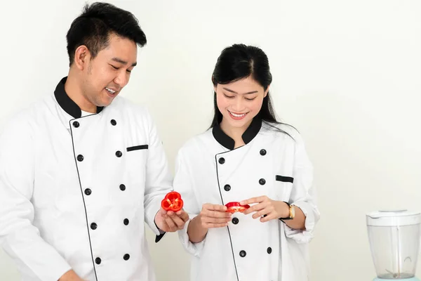 Asiatischer Koch lehrt seine Köchin Helferin zum Schneiden roter Chilischoten — Stockfoto
