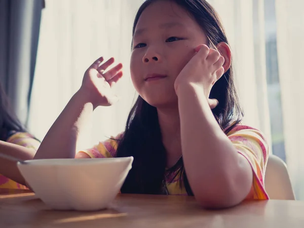 Cute Asian girl eats rice soup for breakfast — Stock Photo, Image