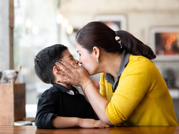 Азиатская мать целует своего сына, образ жизни концепции . — стоковое фото