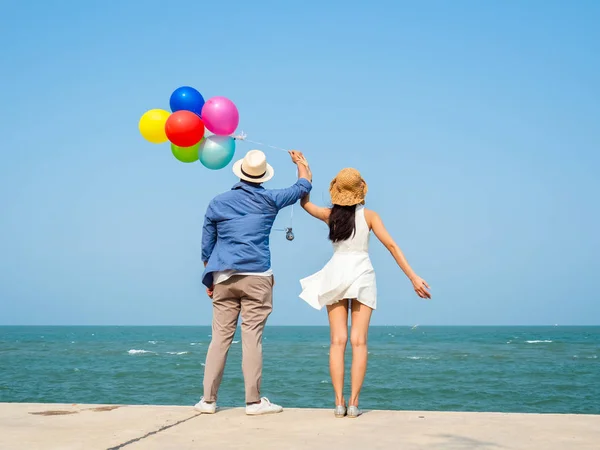 Çift renkli balonlar sahilde güneşli d holding Back — Stok fotoğraf