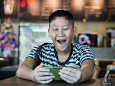 Kahve dükkanında Smartphone kullanarak Asya çocuk, yaşam tarzı kavramı.