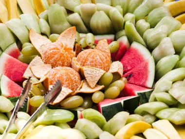 Tropikal meyveler açık büfe masada dilimlenmiş, hizmet vermeye hazır.