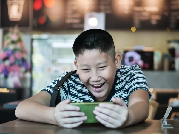 Aziatische jongen met behulp van smartphone in Coffee Shop, lifestyle concept. — Stockfoto