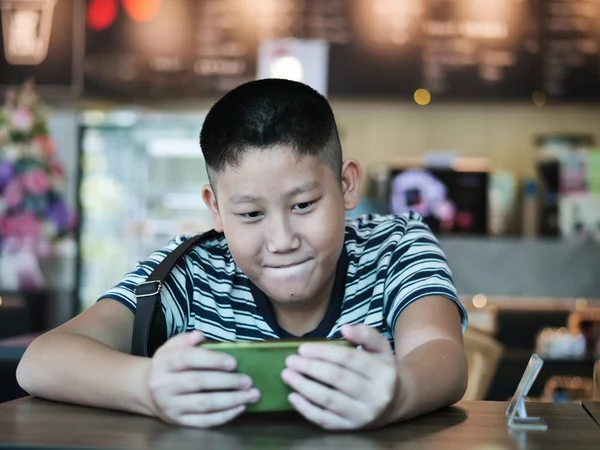 Aziatische jongen met behulp van smartphone in Coffee Shop, lifestyle concept. — Stockfoto