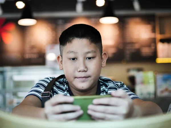 Garçon asiatique en utilisant smartphone dans un café, concept de style de vie . — Photo