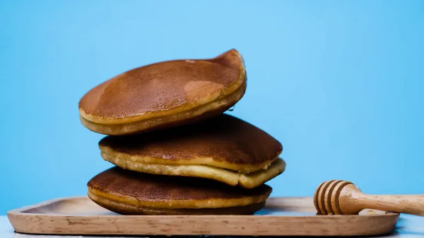 Pancake dengan madu syrub dan latar belakang biru . — Stok Foto