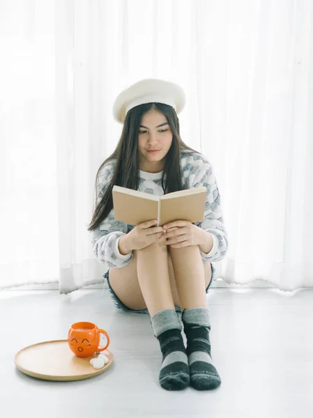 Hermosa chica adolescente con suéter y la lectura de un libro en fl —  Fotos de Stock