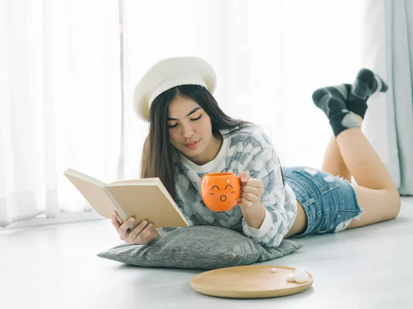 Bella ragazza adolescente indossa maglione e la lettura di un libro su fl — Foto Stock