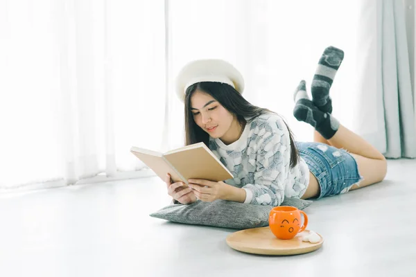 Bella ragazza adolescente indossa maglione e la lettura di un libro su fl — Foto Stock