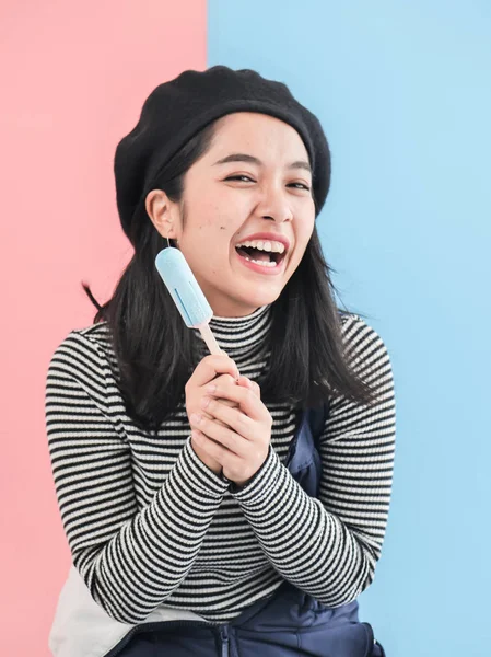 Heureuse femme asiatique tenant bâton de crème glacée bleue avec couleur backgr — Photo