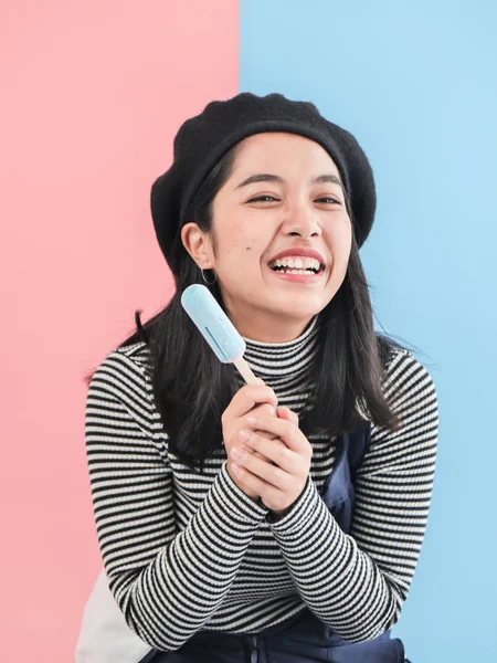 Renkli arka plan müziği ile mavi dondurma sopa tutan mutlu Asyalı kadın — Stok fotoğraf