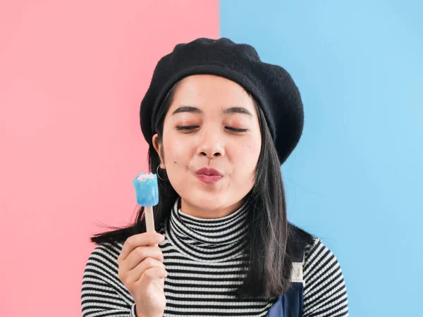 Happy Asian woman holding blue ice cream stick with color backgr — Stock Photo, Image