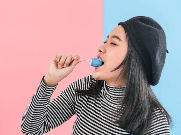 Renkli arka plan müziği ile mavi dondurma sopa tutan mutlu Asyalı kadın — Stok fotoğraf