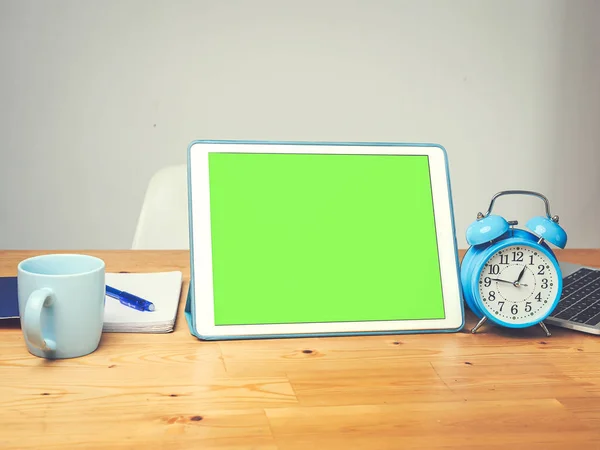 Tableta de pantalla verde y reloj despertador azul en mesa de pino, para burla — Foto de Stock