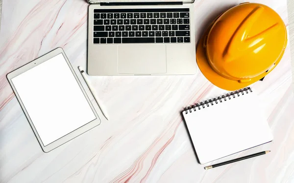 Ingenjör hjälm på bordet med PC och anteckningsblock på Marble bakgrunds — Stockfoto