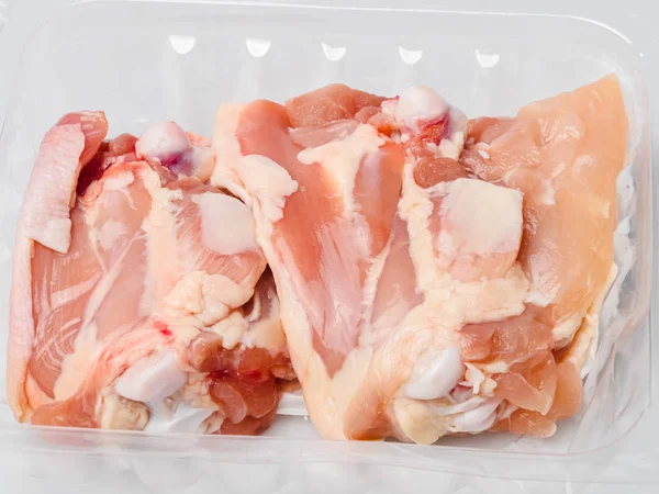 Куриные бёдра в пластиковой упаковке из супермаркета, готовые к приготовлению . — стоковое фото