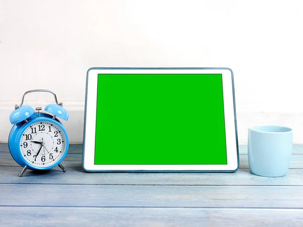 绿屏平板电脑，蓝色闹钟和咖啡杯上 — 图库照片