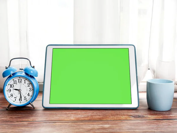PC tableta de pantalla verde, despertador azul y taza de café en — Foto de Stock