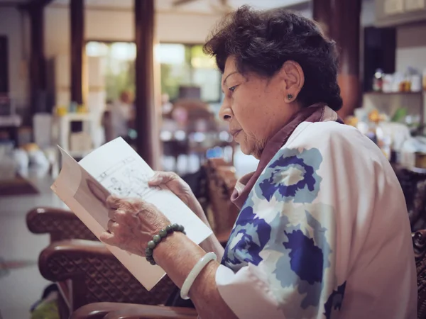 Aziatische Senior vrouw het lezen van een boek met raam licht, Lifestyle c — Stockfoto