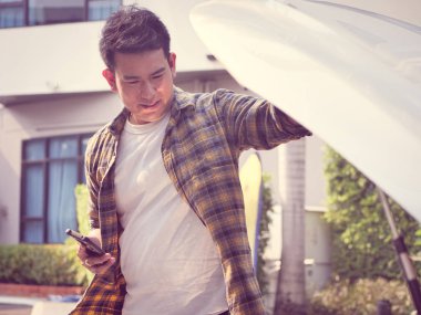 Asya adam araba hood ve yaşam tarzı kavramı onun arabayı kontrol edin.