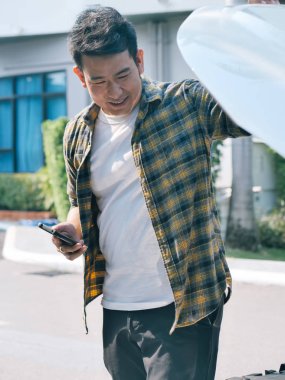 Asya adam araba hood ve yaşam tarzı kavramı onun arabayı kontrol edin.