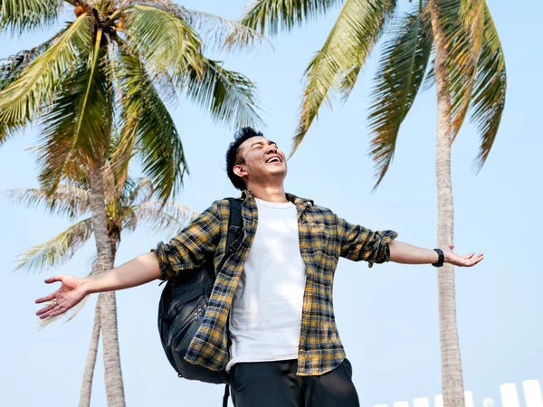 Homem asiático com mochila levantando as mãos com sentimento de felicidade — Fotografia de Stock
