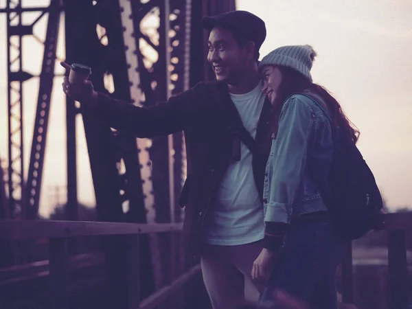 Happy Asian tourist couple drinking takeaway coffee cup with bla