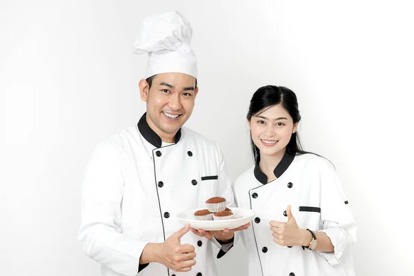 Pulgar hacia arriba los chefs de pastelería con cupcakes en el plato blanco y checki — Foto de Stock