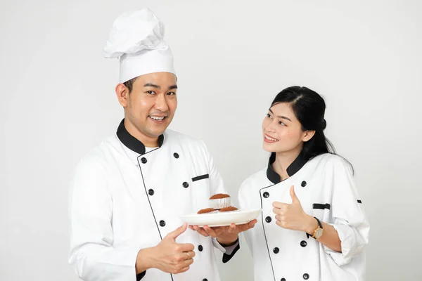 Polegar até pastelaria chefs segurando cupcakes na placa branca e checki — Fotografia de Stock