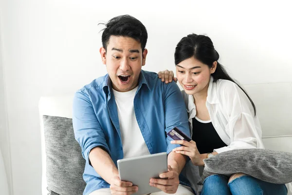 Sorprendente pareja asiática usando tableta en casa, concepto de estilo de vida . — Foto de Stock