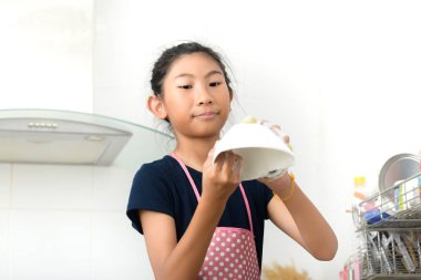 Asyalı kız evde mutfakta bulaşık yıkama, ev işi lifestyl