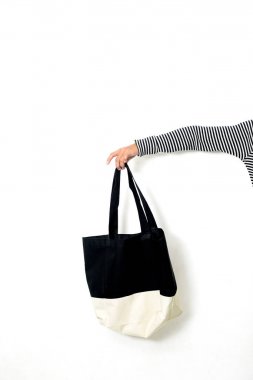 Beyaz arka planda el tutma kumaş çanta.