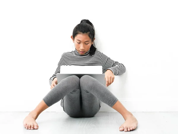 Menina asiática sentada no chão e usando laptop em casa . — Fotografia de Stock