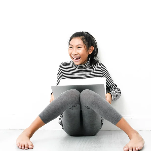 Menina asiática sentada no chão e usando laptop em casa . — Fotografia de Stock