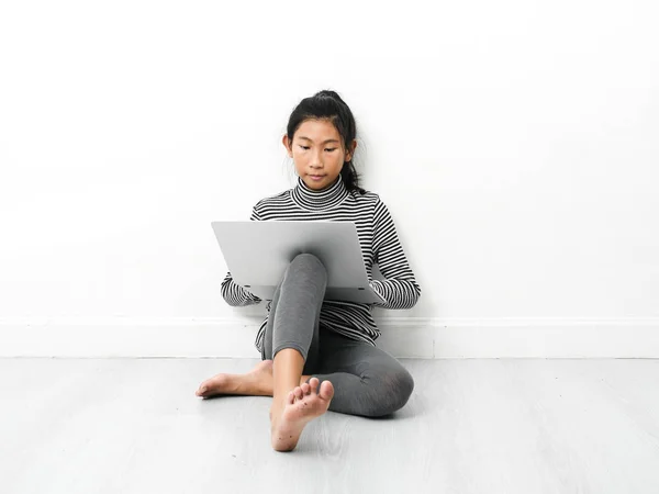 Asian dziewczyna siedzi na podłodze i za pomocą laptopa w domu. — Zdjęcie stockowe