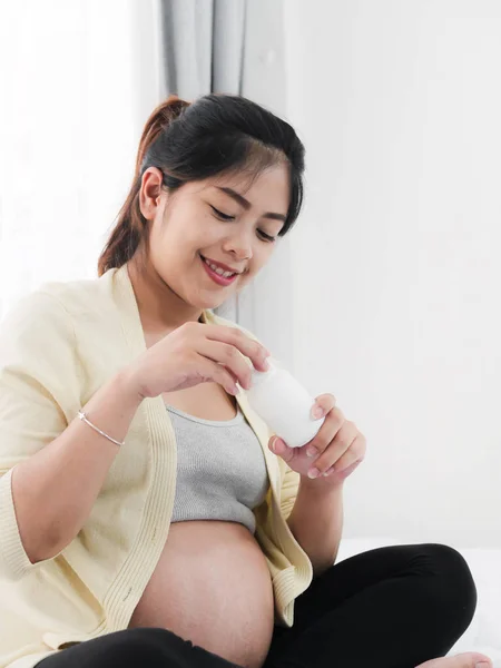 Беременная азиатка с наркотиками в руках, медицинскими препаратами и здоровьем — стоковое фото
