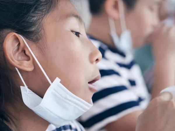 Gesloten Aziatische student meisje met behulp van masker terwijl eten in voedsel kan — Stockfoto