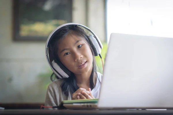 Happy mixed race girl using headphone with smartphone at home. — Stock Photo, Image