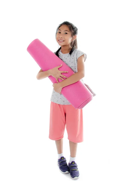 Asiatisk tjej som transporterar rosa yogamatta på vit bakgrund. — Stockfoto